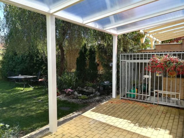 pod bílou hliníkovou pergolou